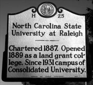 NC Highway Historical Marker on Hillsborough Street displays the official name of the University